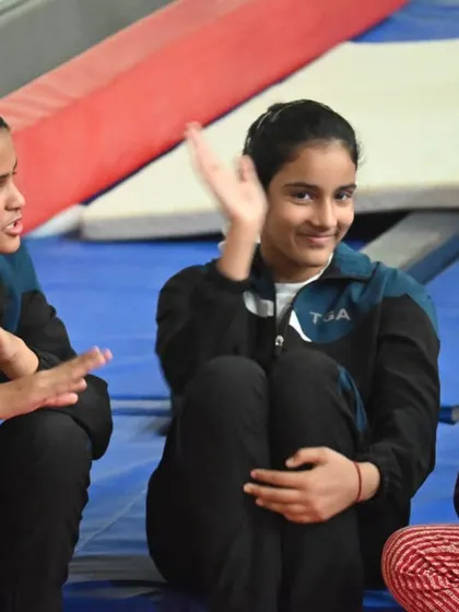 Friends and teammates. Our gymnasts share a laugh during a break, showcasing the fun side of our community.