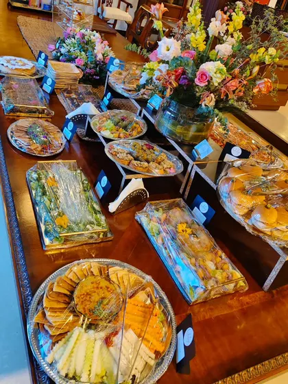 Bright blooms sit between our platters of small bites, with sandwiches and little dishes raised on stands along the table.