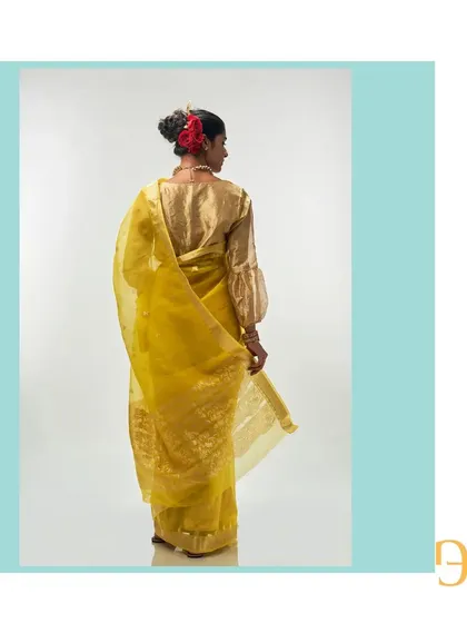 The back of the cadmium yellow saree, showing the beautiful fall of the organza and the rich detail of the pallu.