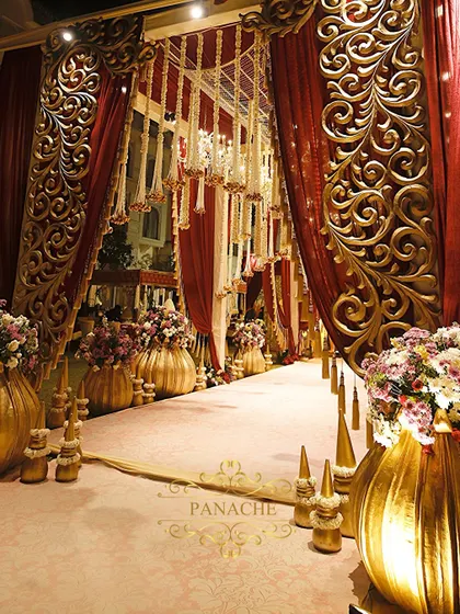 The entrance to the royal affair, lined with oversized golden vases and lush floral arrangements. We design these pathways to build anticipation and immerse guests in the theme from the moment they arrive.
