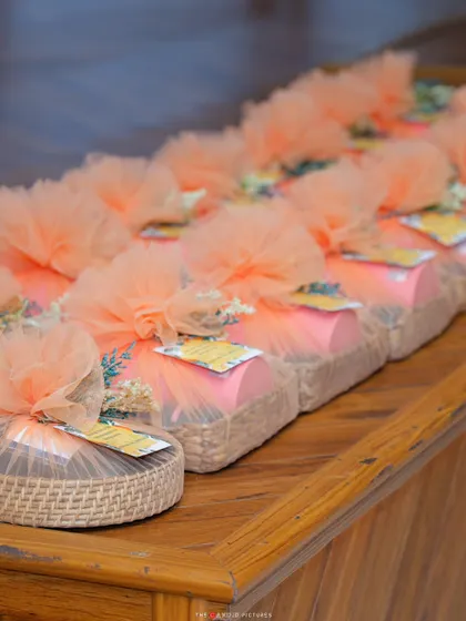 Thoughtfully prepared return favors, wrapped in peach-colored tulle and tied with a custom tag, ready to thank guests for celebrating the special day.