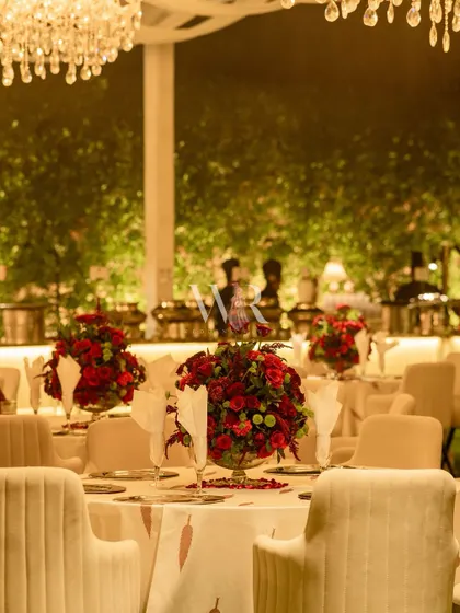 A table set for dinner, with a centerpiece of red roses and a custom-printed tablecloth. The focus is on creating a cohesive and beautifully branded dining experience.