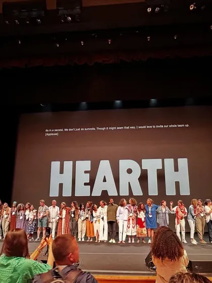 A series of images and graphics from the Hearth Summit, showcasing speakers, panel discussions, and the core mission of the global wellbeing project.
