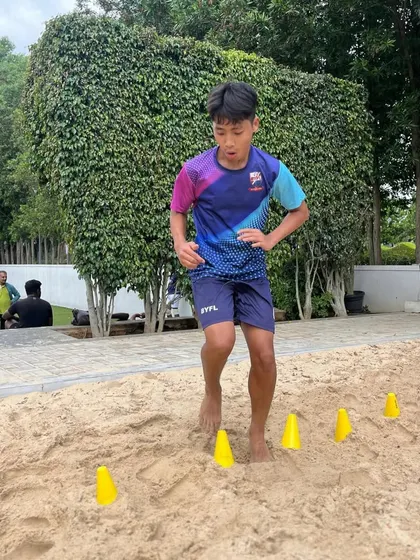 A player works on agility drills using cones on the sand, improving his footwork and speed.