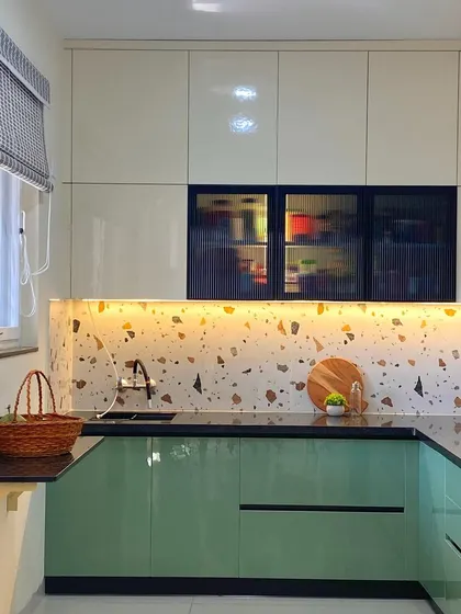 The glossy finish on the cabinets reflects light, making this compact kitchen feel bright and spacious.