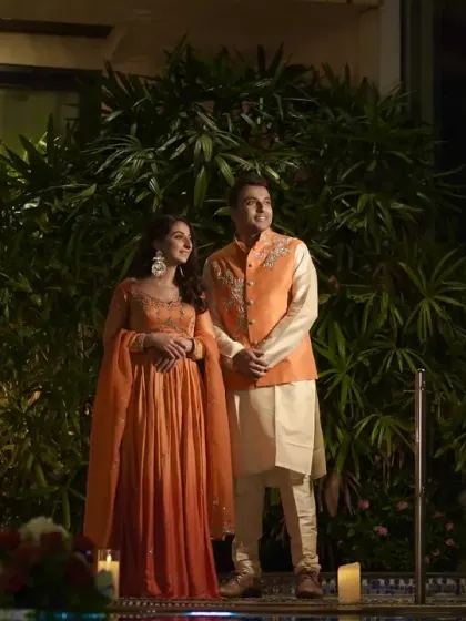 The couple posing by the poolside, surrounded by the warm glow of candles.