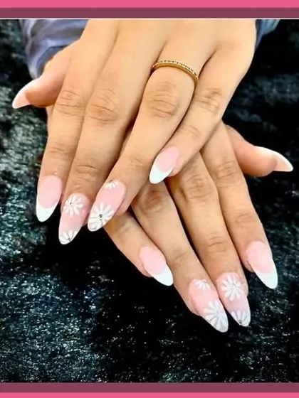 A beautiful example of a classic French manicure with delicate white daisy art on the accent nails.