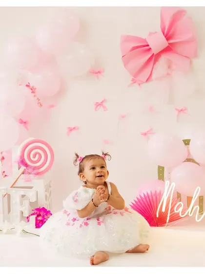 Mahhira is ONE! This personalized setup with her name, balloons, and a lollipop makes her first birthday shoot extra special.