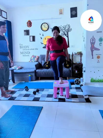 A client performs step-ups with dumbbells, with me spotting her. This ensures safety and proper form, allowing her to push her limits confidently.