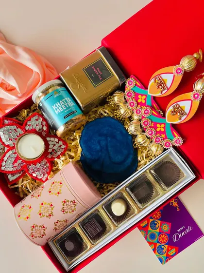 A different angle of the classic red Diwali box, showing the variety of textures and colors of the items inside.