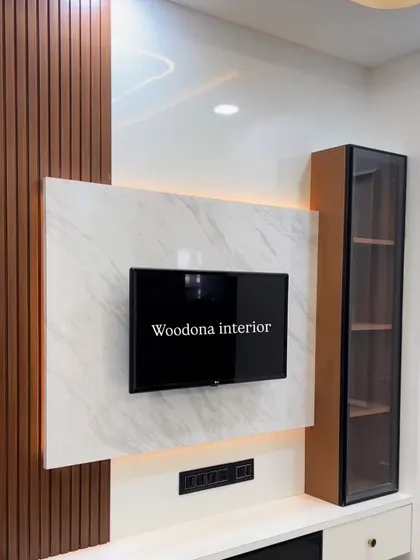 Here is a stylish TV unit featuring a mix of materials. We used dark wood fluted panels, a white marble-finish backdrop, and a sleek glass-fronted display cabinet to create a modern and functional piece.