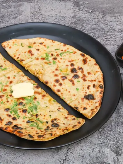 A classic breakfast or lunch, my Aloo Paratha is stuffed with a spiced potato filling and served with a dollop of butter, yogurt, and pickle.