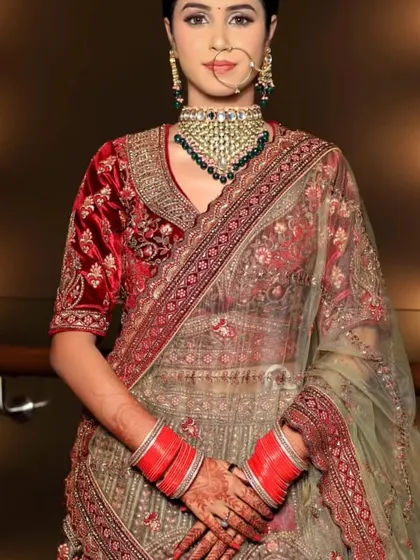 A full-length view of the bride, showcasing the beautiful contrast of the green dupatta with the red velvet blouse.