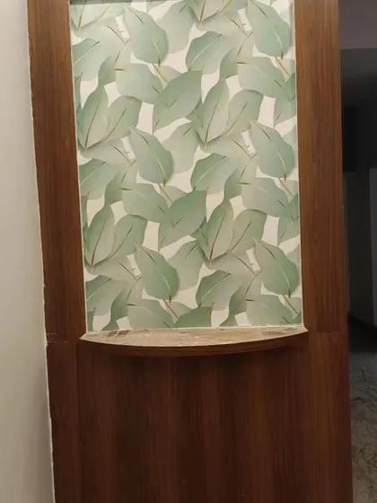 A small section of wall with a green leaf pattern, framed by wood, acting as a decorative niche.