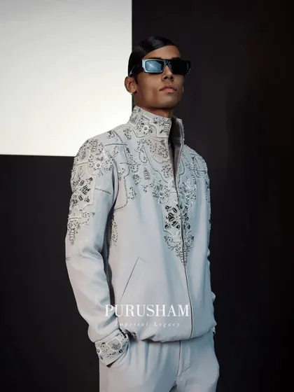 This is my take on a modern bomber jacket. Crafted in a light grey fabric, it is covered in intricate, swirling embroidery, transforming a casual silhouette into a piece of wearable art.