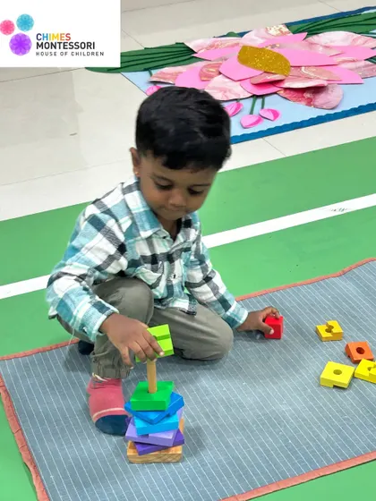 A new student explores stacking blocks, developing hand-eye coordination and an early understanding of physics and balance.