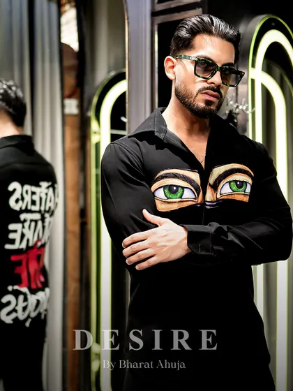 This shirt is designed to stare back. The front features a pair of hand-painted, piercing green eyes, while the back makes a bold statement: 'Haters Make Me Famous'. It's art with an attitude.