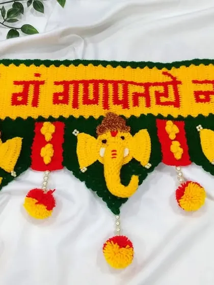 This is my most popular Ganpati toran, a design that brings blessings to your doorstep. I carefully crochet each element, from the "ॐ गं गणपतये नमः" text to the bright yellow Ganpati faces and colorful pom-poms, using durable 4-ply acrylic yarn.