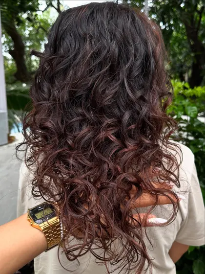 A close-up shot of the curl definition and the rich, chocolatey tones we added. Coloring curls is an art.