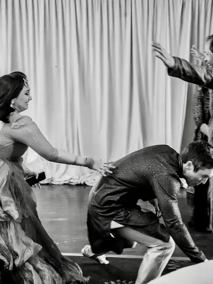 The 'joota chupai' or shoe-stealing ritual in action. This black and white series captures the playful fight for the groom's shoes.