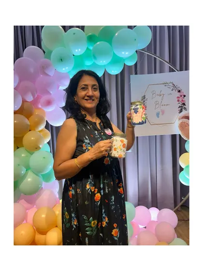 A guest at a "Baby in Bloom" themed shower, holding up her beautifully decorated floral jar. The decor and activity were perfectly matched.
