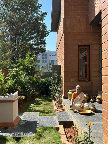 The lady of the house enjoying the 'ಜಗಲಿ' (jagali), a space that truly comes alive when it's used and loved. The design is meant to be part of daily life.