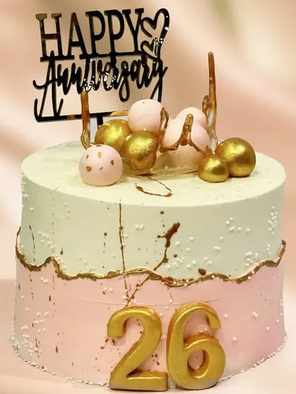 A lovely two-toned cake celebrating a 26th anniversary. The gold accents, decorative spheres, and "Happy Anniversary" topper make it a festive and elegant choice.
