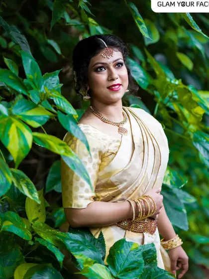 This look captures the beautiful traditions of Onam. I created a minimalistic makeup look with a bold red lip and paired it with a floral messy bun to complement the classic Kasavu saree. It’s all about celebrating with elegance.