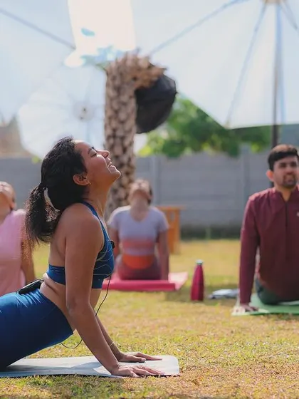 An instructor leads the class through a pose during our Pawga event, surrounded by the beautiful greenery of the camp.