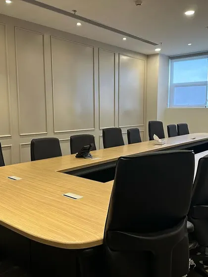 This conference room in Ambala is designed for productivity. It features a large U-shaped table to facilitate discussion, ergonomic chairs for comfort during long meetings, and classic wall paneling for a sophisticated look.