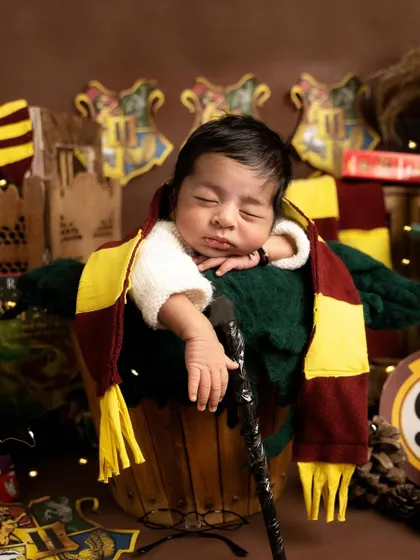 Even wizards need their rest. This adorable shot captures our baby Harry Potter dozing off in a bucket, his magic wand resting by his side.