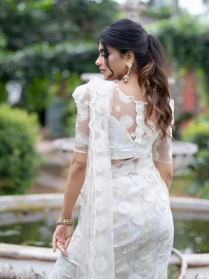 A back view of the white self-embroidered saree, showing the beautiful design of the blouse.