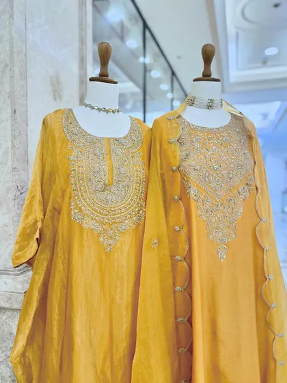 A pair of stunning yellow kurtas with heavy silver embroidery on the neckline. These pieces are designed to make you shine at any festive event.