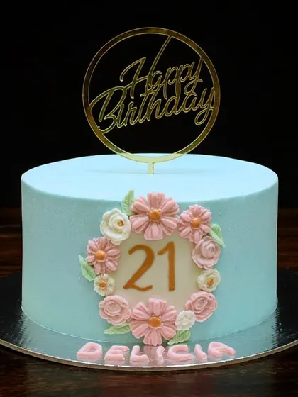 A sweet and elegant cake for a 21st birthday. The light blue buttercream is the perfect backdrop for a delicate wreath of hand-piped pink and white flowers.