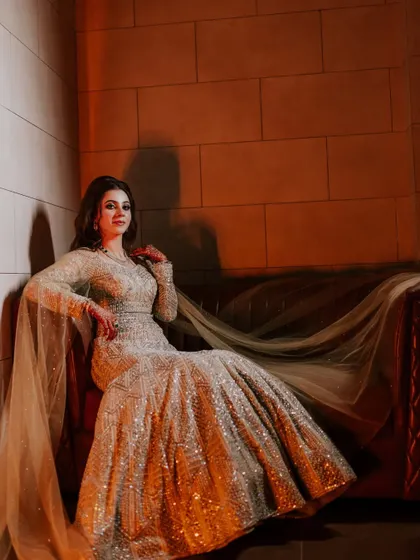A solo portrait of the bride-to-be, seated and looking elegant in her shimmering gown.