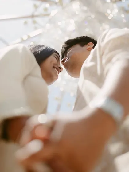 A fun, low angle shot looking up at the couple against a glass ceiling. We love finding creative perspectives that make your couple portraits unique and dynamic.
