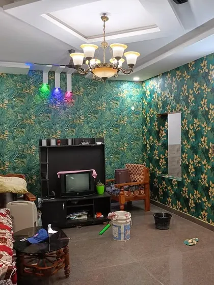 Another angle of the green and gold living room, showing the full space.