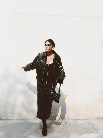 A dynamic shot of Kavya Trehan in motion. The play of light and shadow against the white wall creates a high-impact, minimalist fashion photograph.