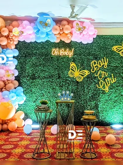 A "Boy or Girl" gender reveal party with a butterfly theme. I used a green hedge wall as the base, decorated with pink and blue balloons and gold butterfly cutouts for a modern and fun look.