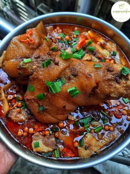 A giant pork leg cooked with fermented soybeans and bamboo shoots, garnished with spring onions and king chilli. This was a special meal for my team!
