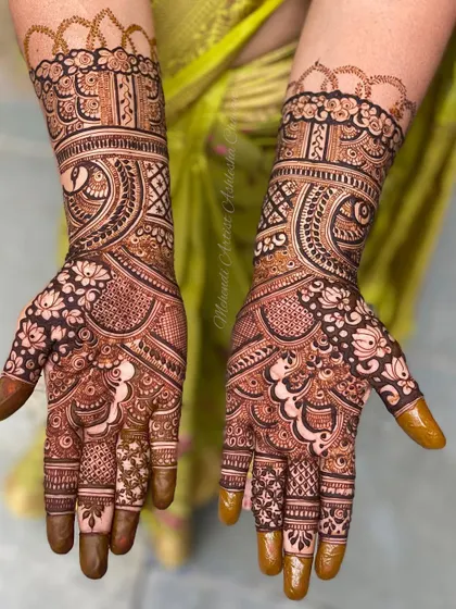 A classic Indian mehendi design with dense, intricate patterns. The use of negative space makes the peacock and floral motifs pop.