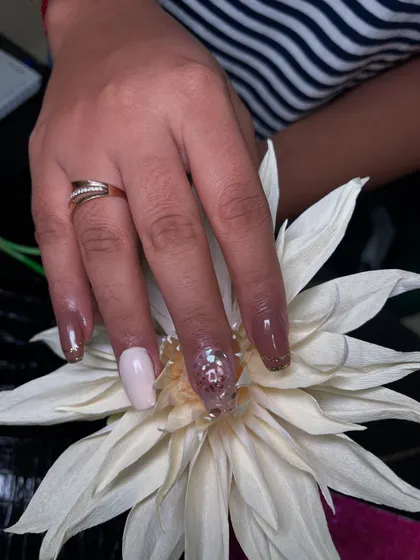 A beautiful set of acrylic extensions combining solid colors with a statement nail. The ring finger is adorned with chunky glitter and sequins for a touch of sparkle.