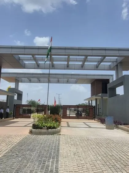 The completed entrance gate at Aamby City, Hoskote, featuring modern architectural design and initial planting.