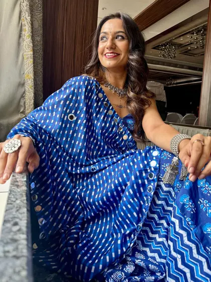 A confident and happy Navratri look. The silver jewelry and blue tones in her makeup create a cohesive and stylish festive appearance.