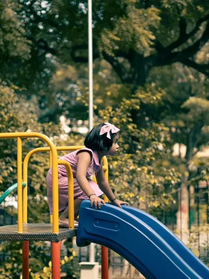 A moment of anticipation before going down the slide. These quiet, in-between moments are just as precious as the big, energetic ones.
