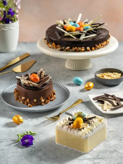 An assortment of Easter-themed chocolate cakes and pastries, decorated with chocolate eggs and shavings for a festive menu shoot.