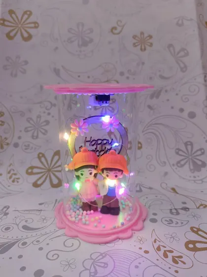 The couple showpiece with the multi-color LED lights turned on. The lights add a festive and magical feel to the romantic scene inside.