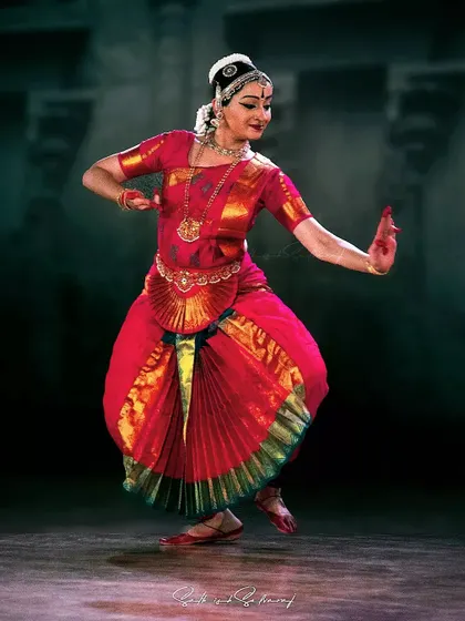 A full-stage view of a dynamic pose during the Natyanjali Festival in Coimbatore. This image captures the grace and expansive movement that defines the Thanjavur style of Bharatanatyam.