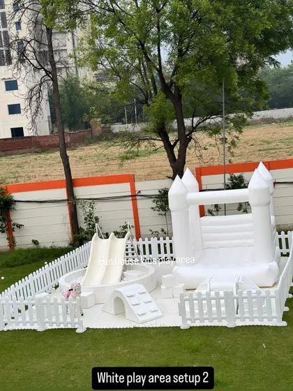 This complete white play area package includes a bouncy castle and a separate ball pit with a slide, offering multiple activities in one cohesive and stylish setup.