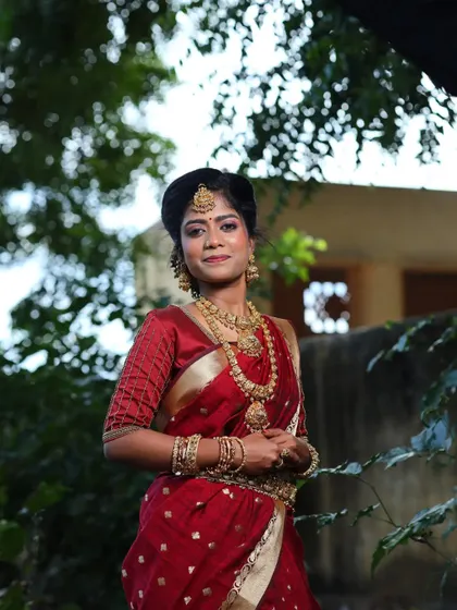A full view of the model in the maroon saree and antique jewellery set.
